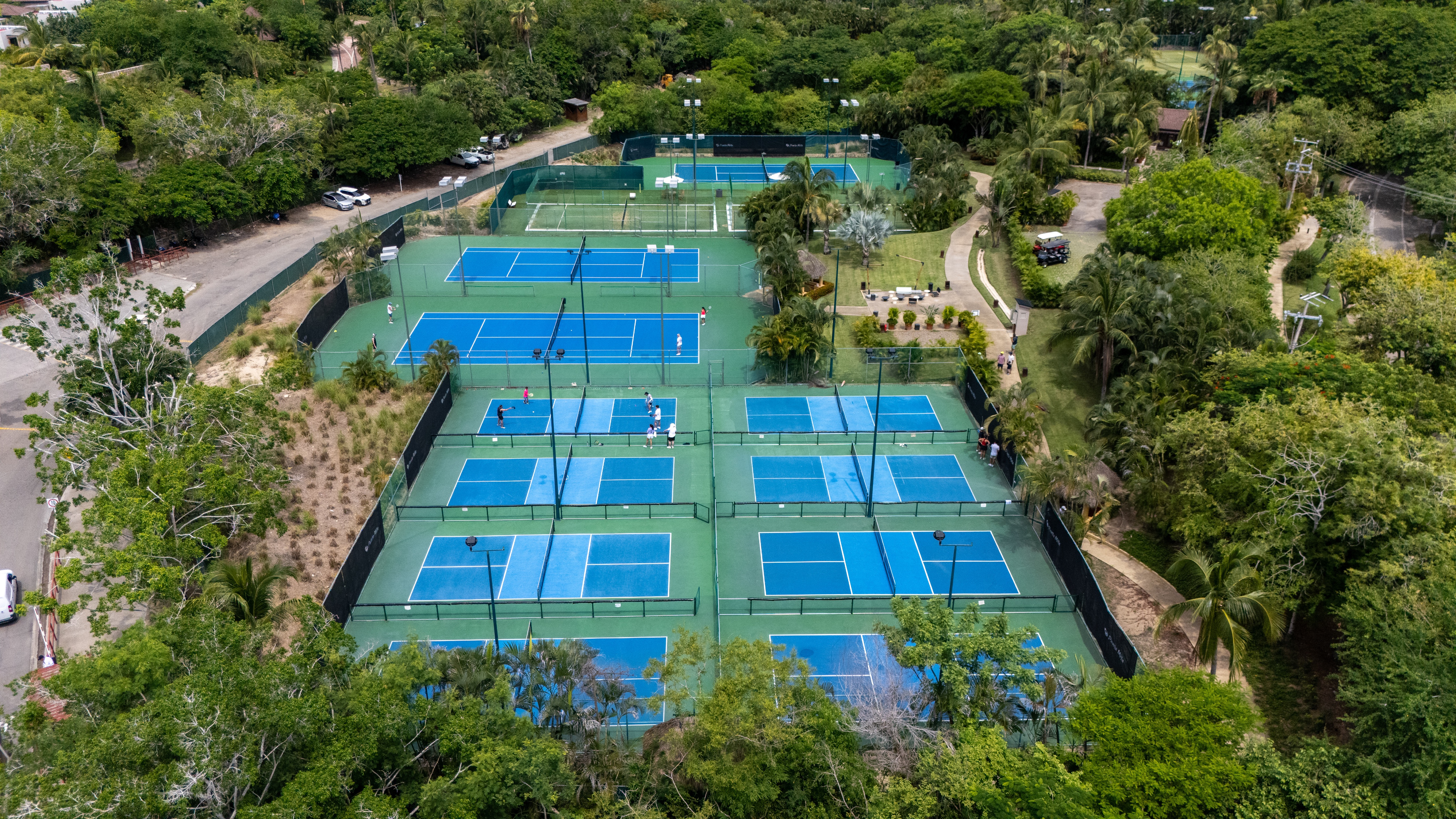 Overhead image of nine pickleball courts and four tennis courts